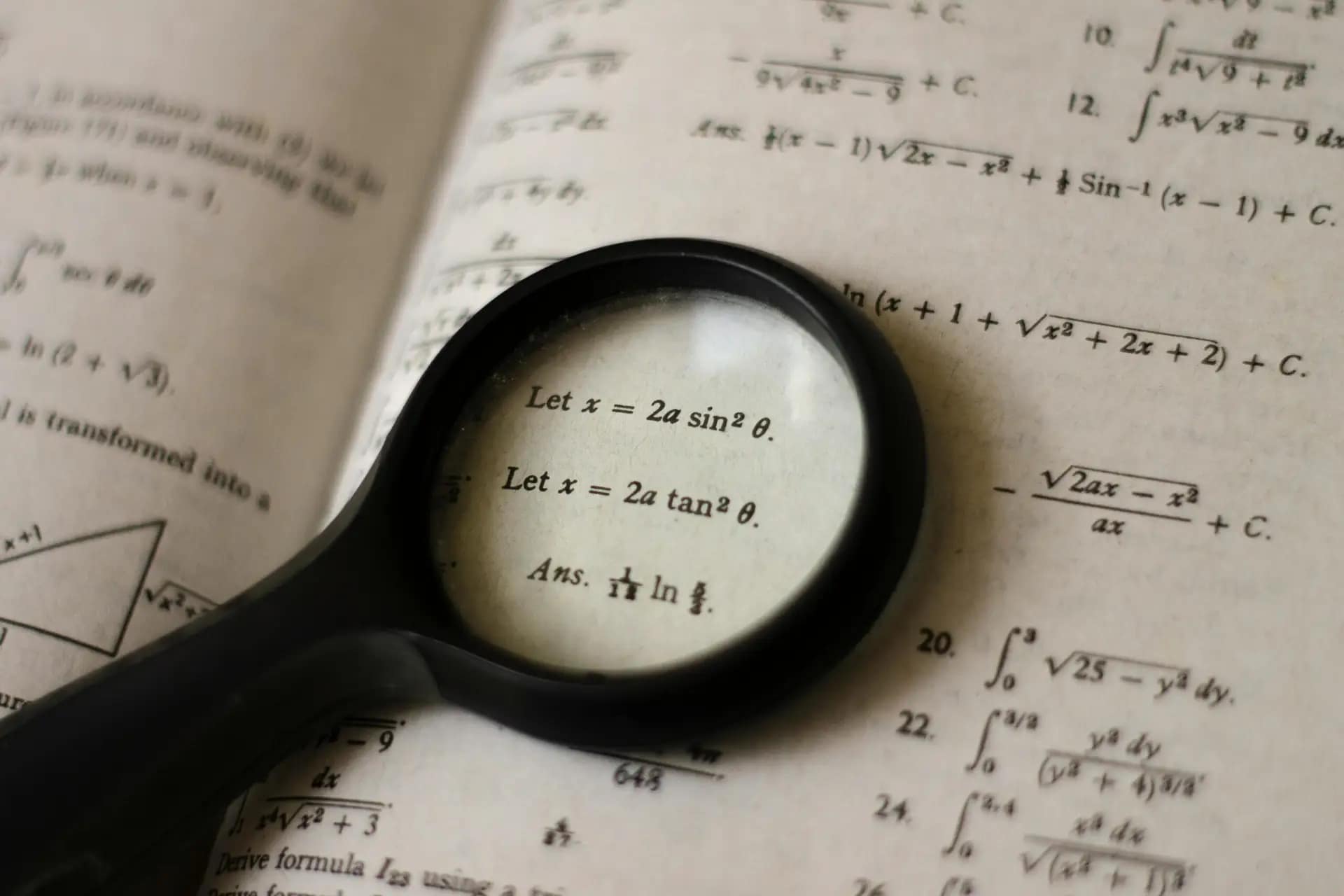 Magnifying glass over a mathematics book